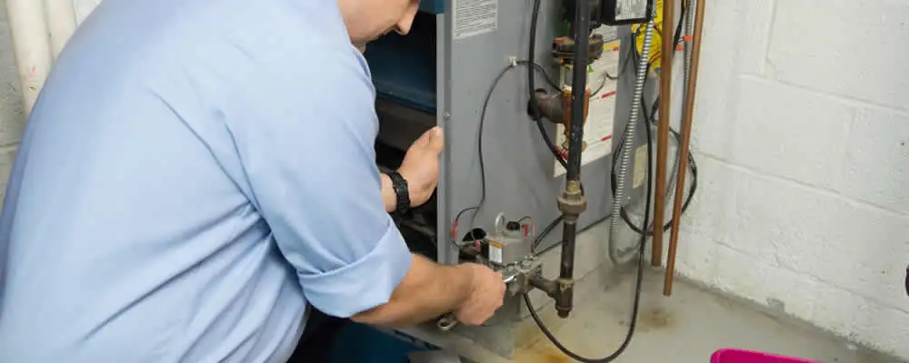 Furnace repair technician inspecting and servicing a home heating system in Miami, FL