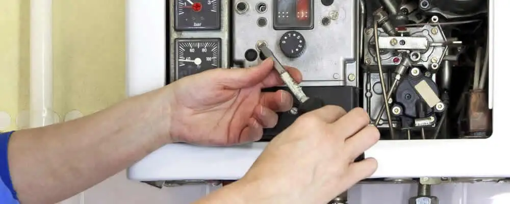 Heating repair technician adjusting boiler controls and components in Miami, FL