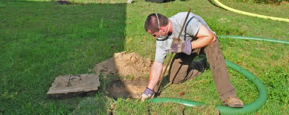Septic pumping technician servicing a residential septic tank in Miami, FL